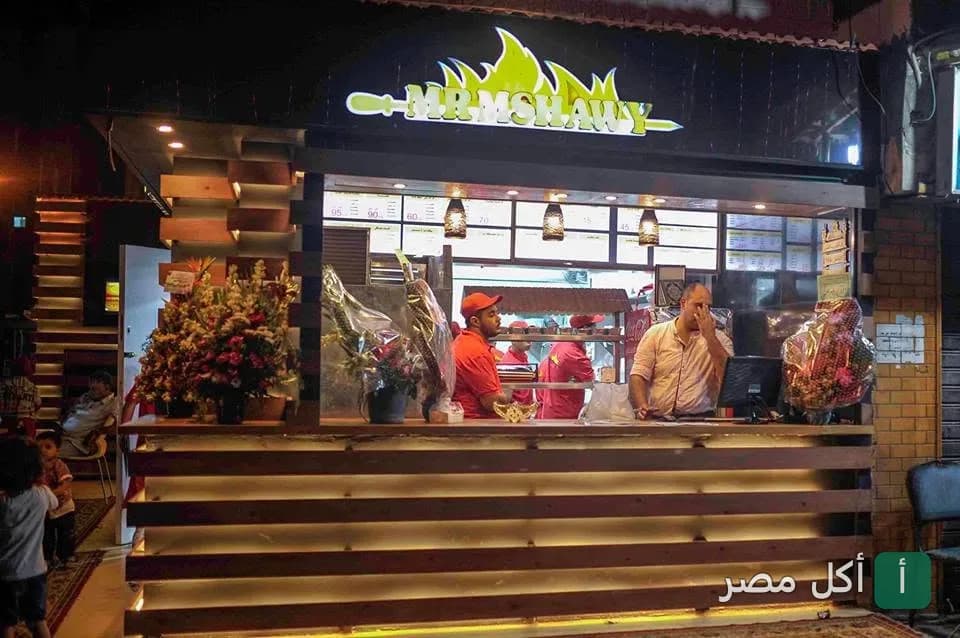 واجهة مطعم مستر مشاوي في بور فؤاد، يظهر الموظفون داخل كاونتر الطلبات المضيء.