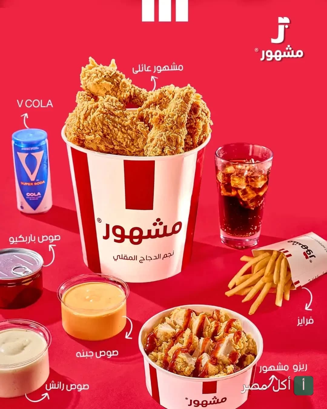 وجبة عائلية من مطعم مشهور تضم دجاج مقلي، ريزو، بطاطس مقلية، صوصات متنوعة ومشروب غازي على خلفية حمراء.