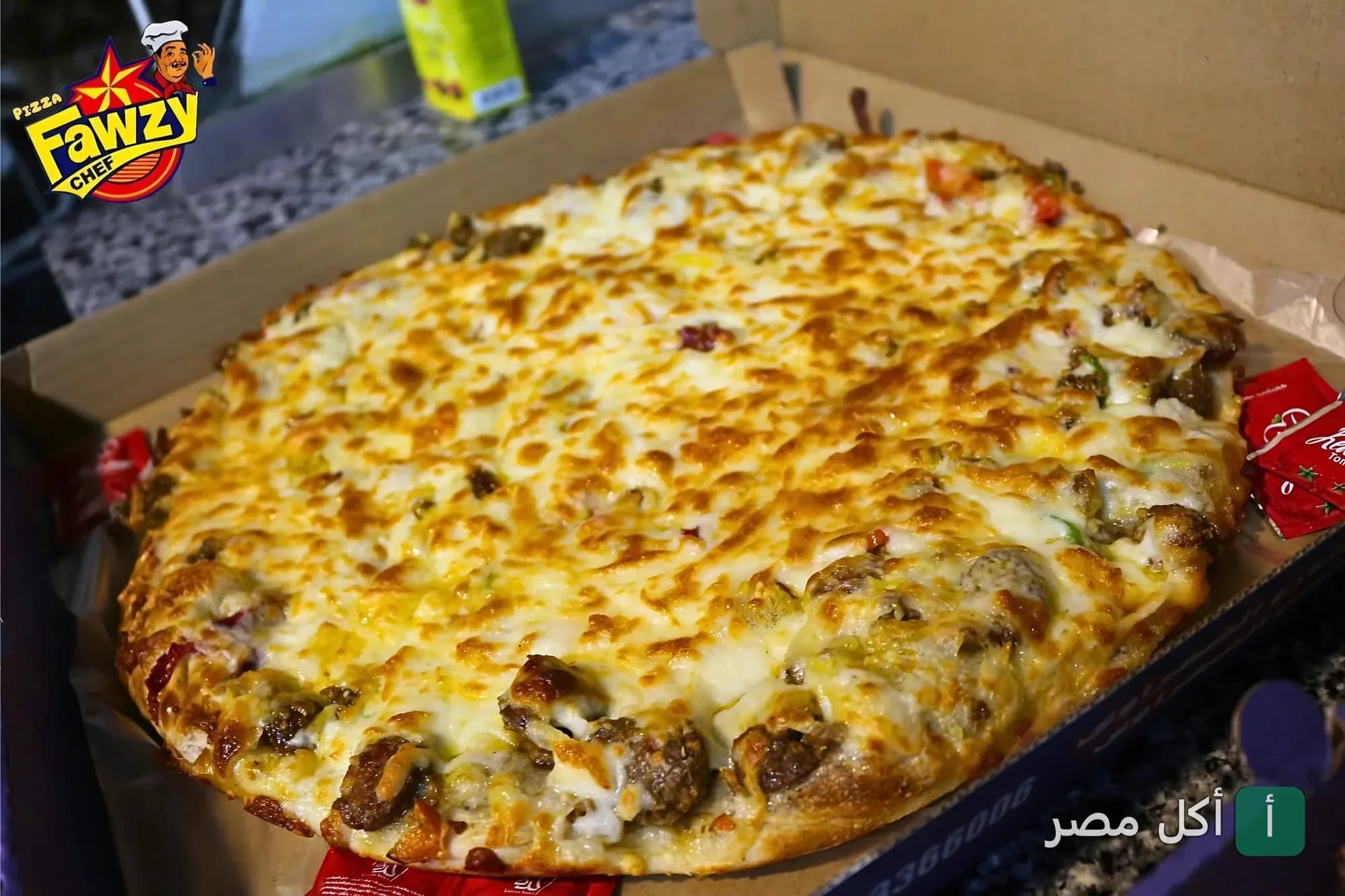 بيتزا باللحم والجبنة السايحة في علبة كرتون من مطعم بيتزا فوزي شيف في بورسعيد.