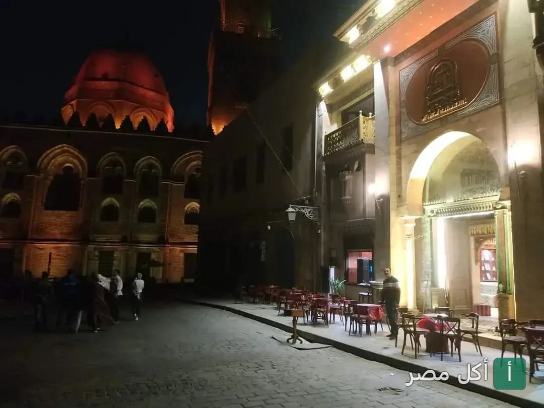 جلسات خارجية لمطعم شارع المعز ساقية بيت القاضي ليلاً في منطقة الجمالية التاريخية.