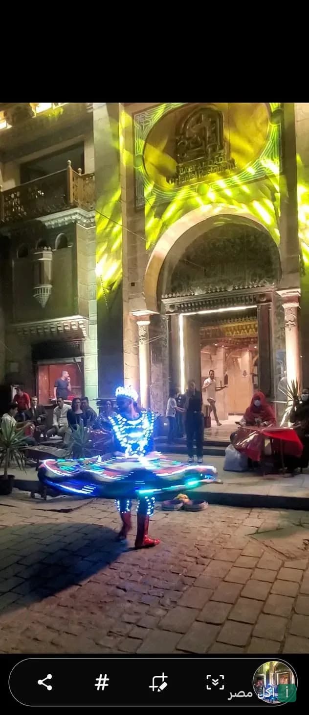 عرض تنورة مضيئة أمام مدخل مطعم شارع المعز ساقية بيت القاضي في الجمالية.