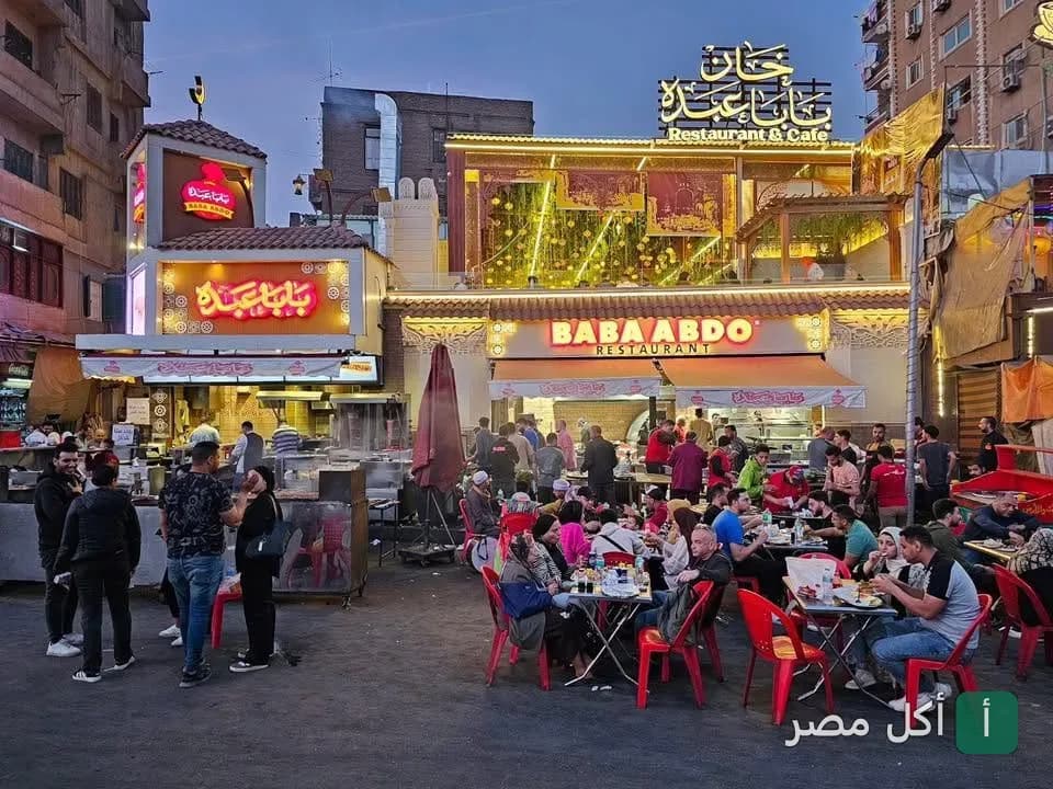واجهة مطعم بابا عبده في منطقة باب الفتوح التاريخية بالقاهرة مع زبائن يتناولون الطعام في الهواء الطلق.