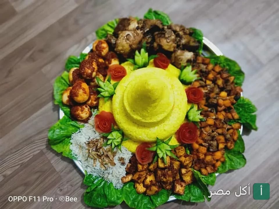 طبق أرز أصفر مخروطي مزين بالخضروات والبيض والدجاج في مطعم بي كوليناري بحارة سيدي معاذ.