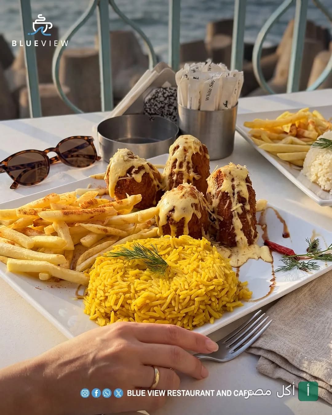 طبق مأكولات بحرية مع أرز أصفر وبطاطس مقلية في مطعم بلو فيو بسيدي جابر