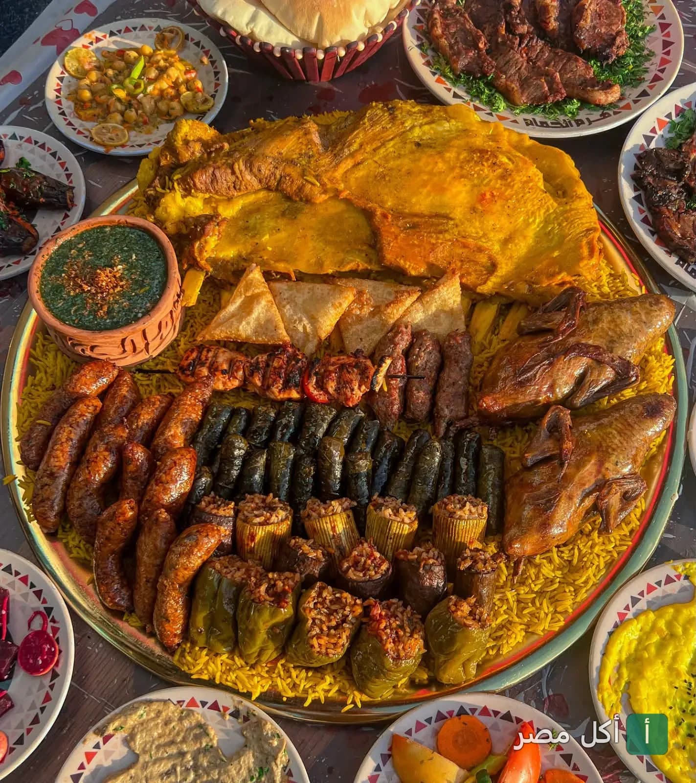 صينية مشاوي مشكلة من مطعم هرم الحمام في سيدي جابر تضم الحمام المحشي والمحاشي والمشاوي على أرز أصفر.