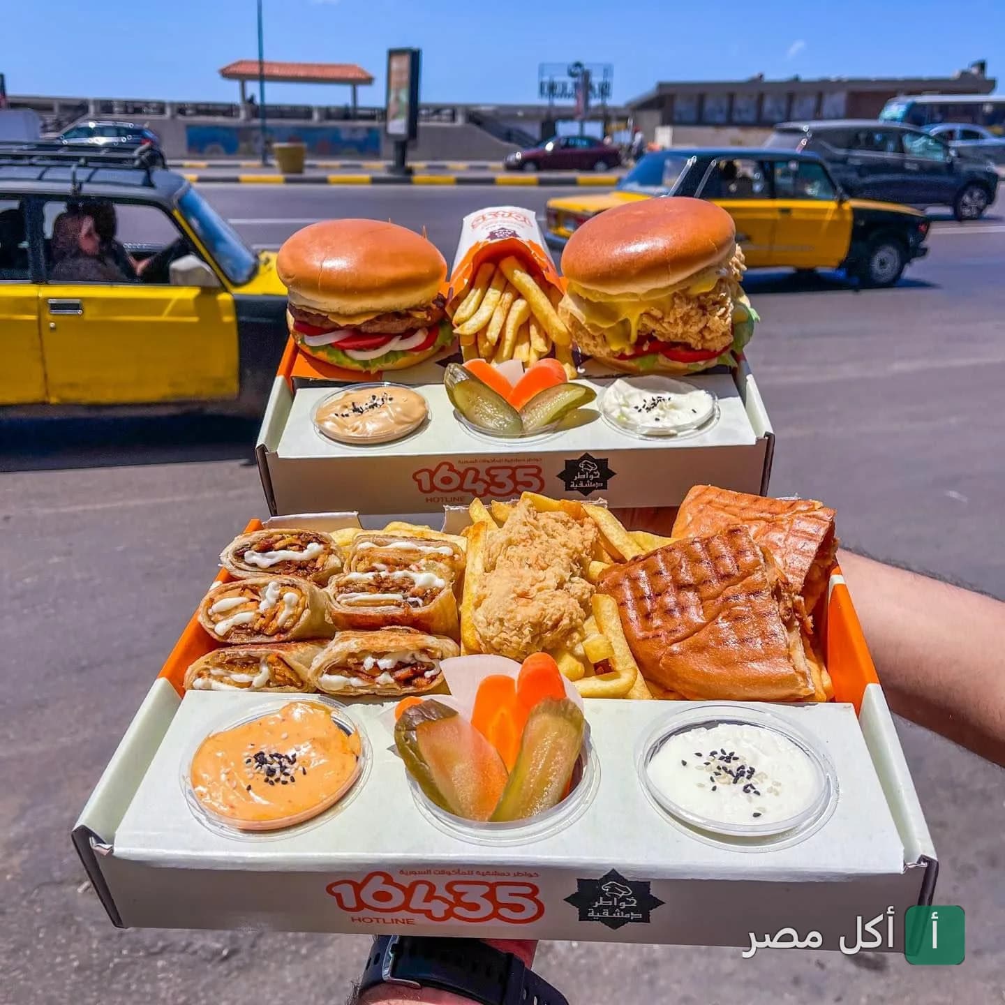 وجبات سريعة من مطعم خواطر دمشقية في سيدي جابر، تشمل برجر، ساندوتشات مقطعة، بطاطس مقلية ومقبلات.