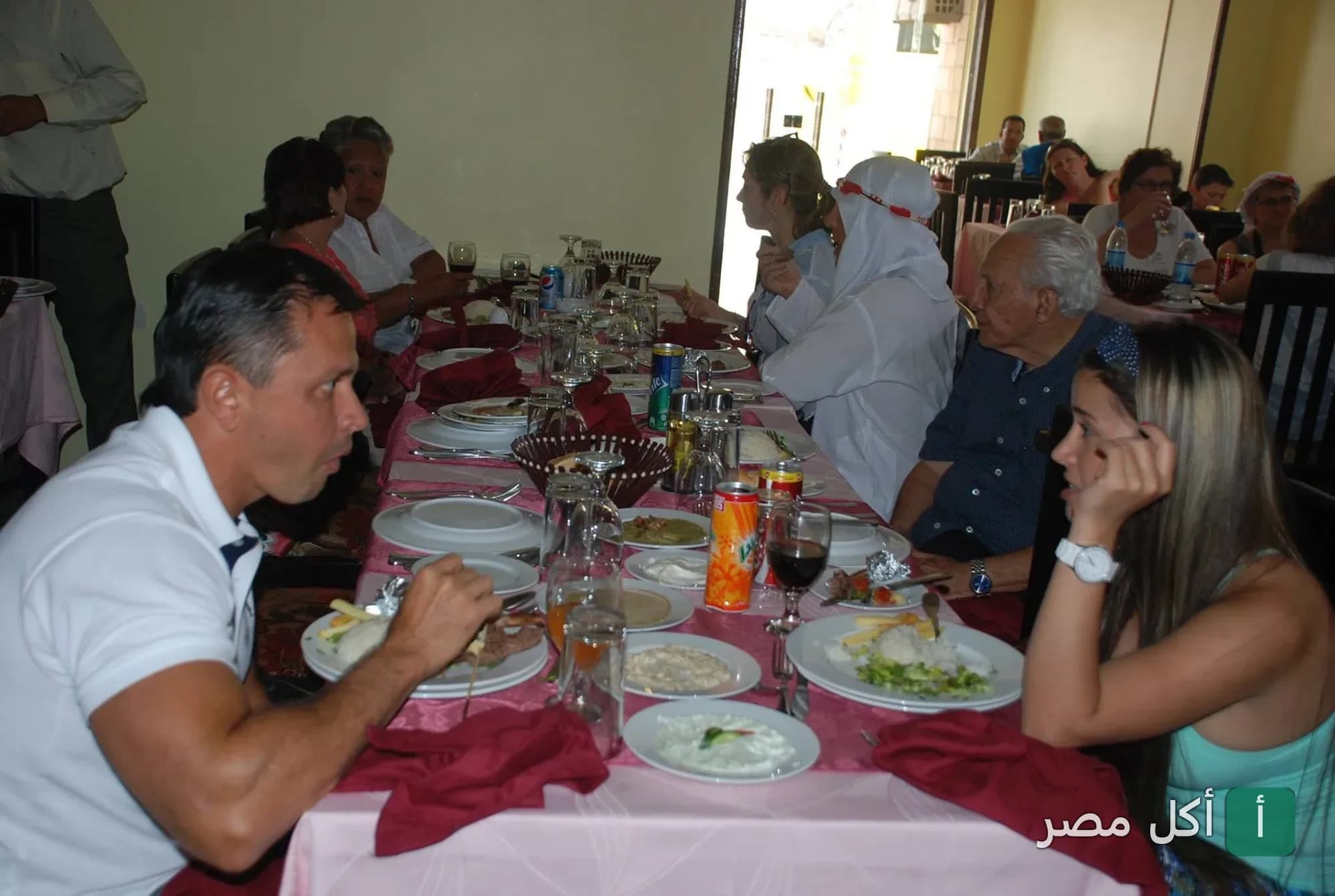 مجموعة من الزبائن يتناولون الطعام في أجواء مريحة داخل مطعم الدار دارك بالهرم.