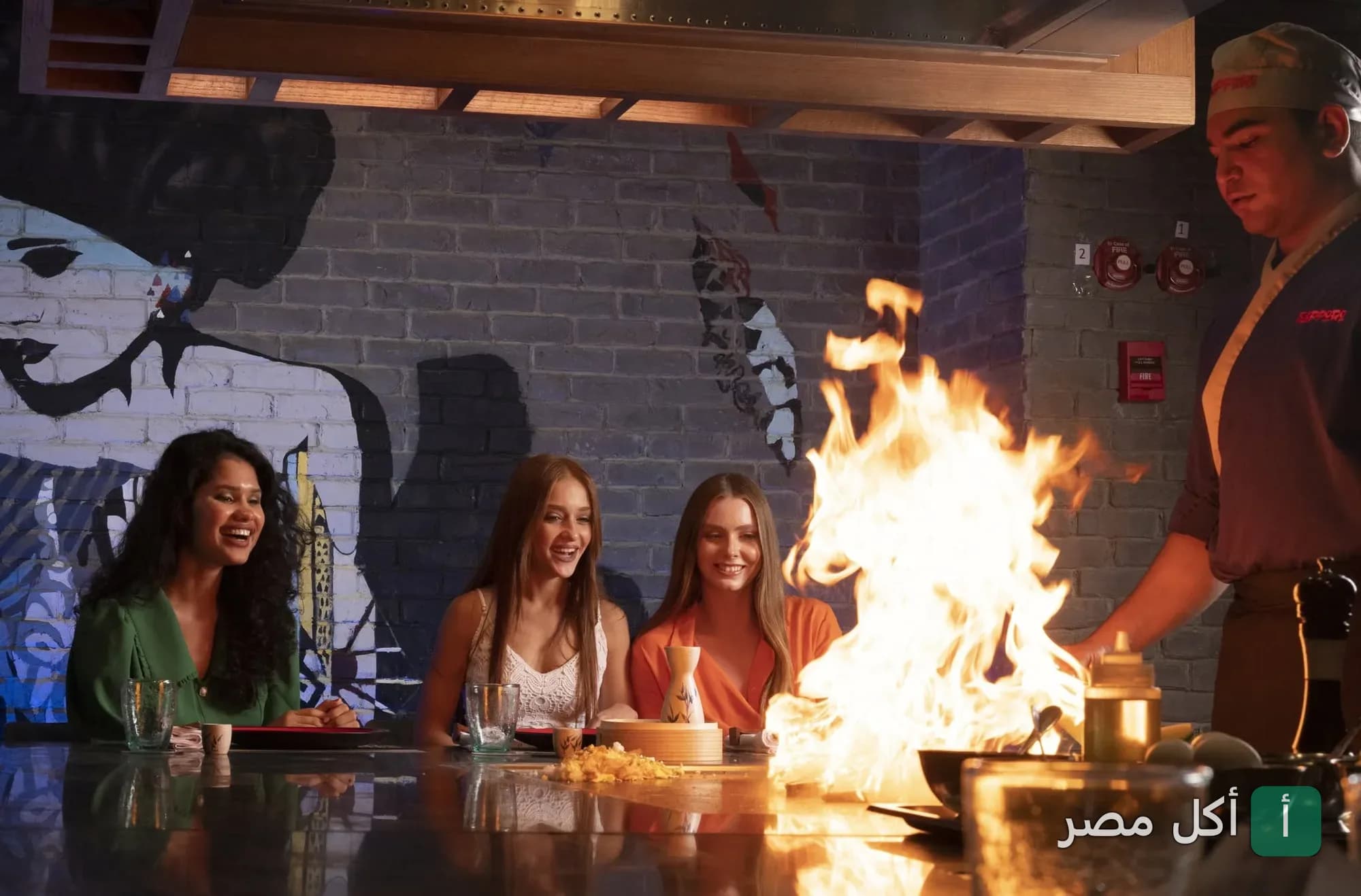 طاهي يحضر الطعام أمام الزبائن على طاولة تيبانياكي في مطعم سابورو الياباني بالدقي.