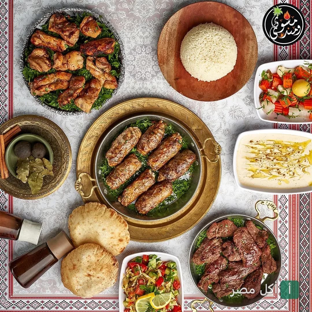 سفرة مشويات متنوعة تضم كباب وكفتة ومندي مع مقبلات وسلطات في مطعم مشوي و مندي بجزيرة الدهب، الجيزة.