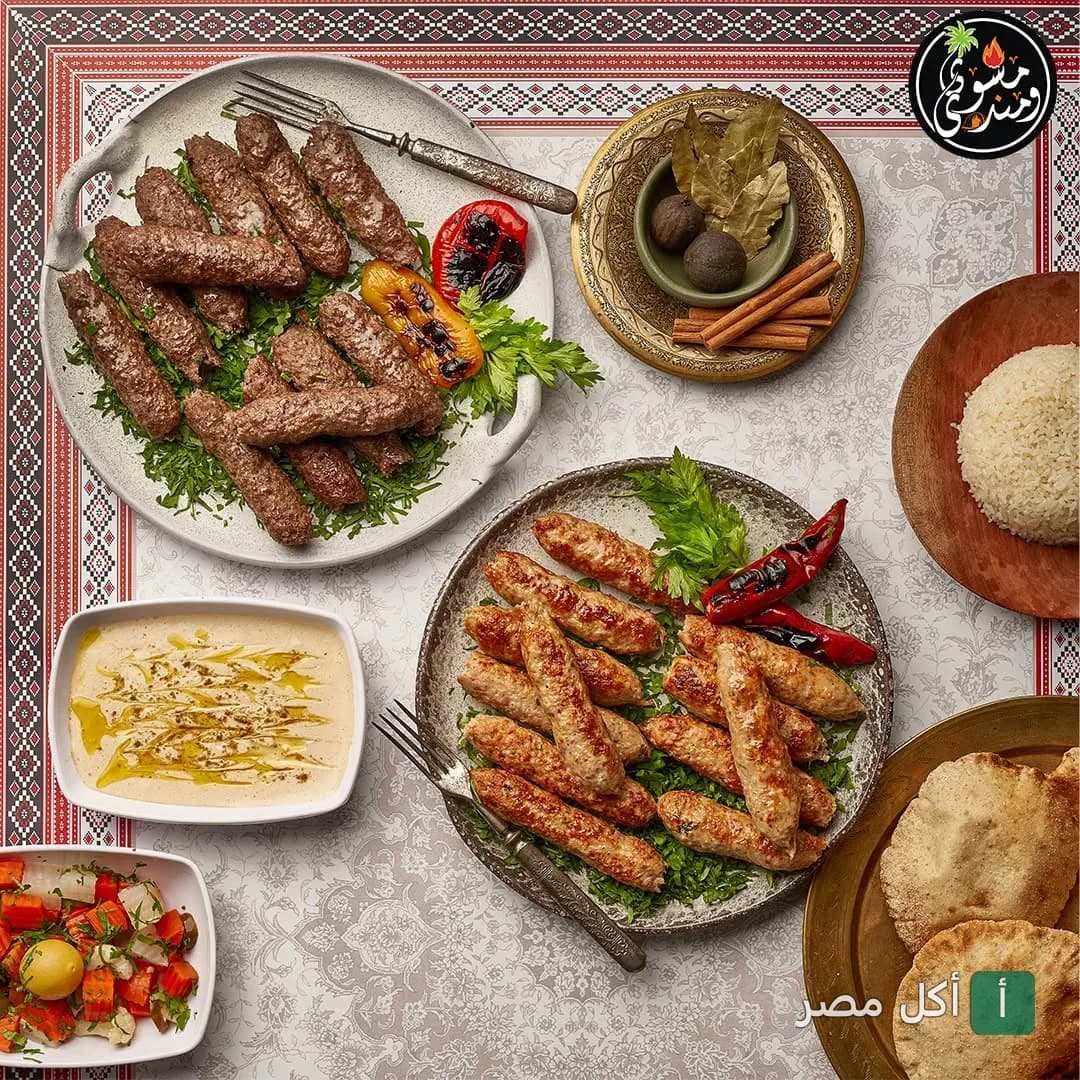 سفرة مشويات متنوعة من مطعم مشوي و مندي في جزيرة الدهب بالجيزة، تضم كفتة، طحينة، أرز ومقبلات.
