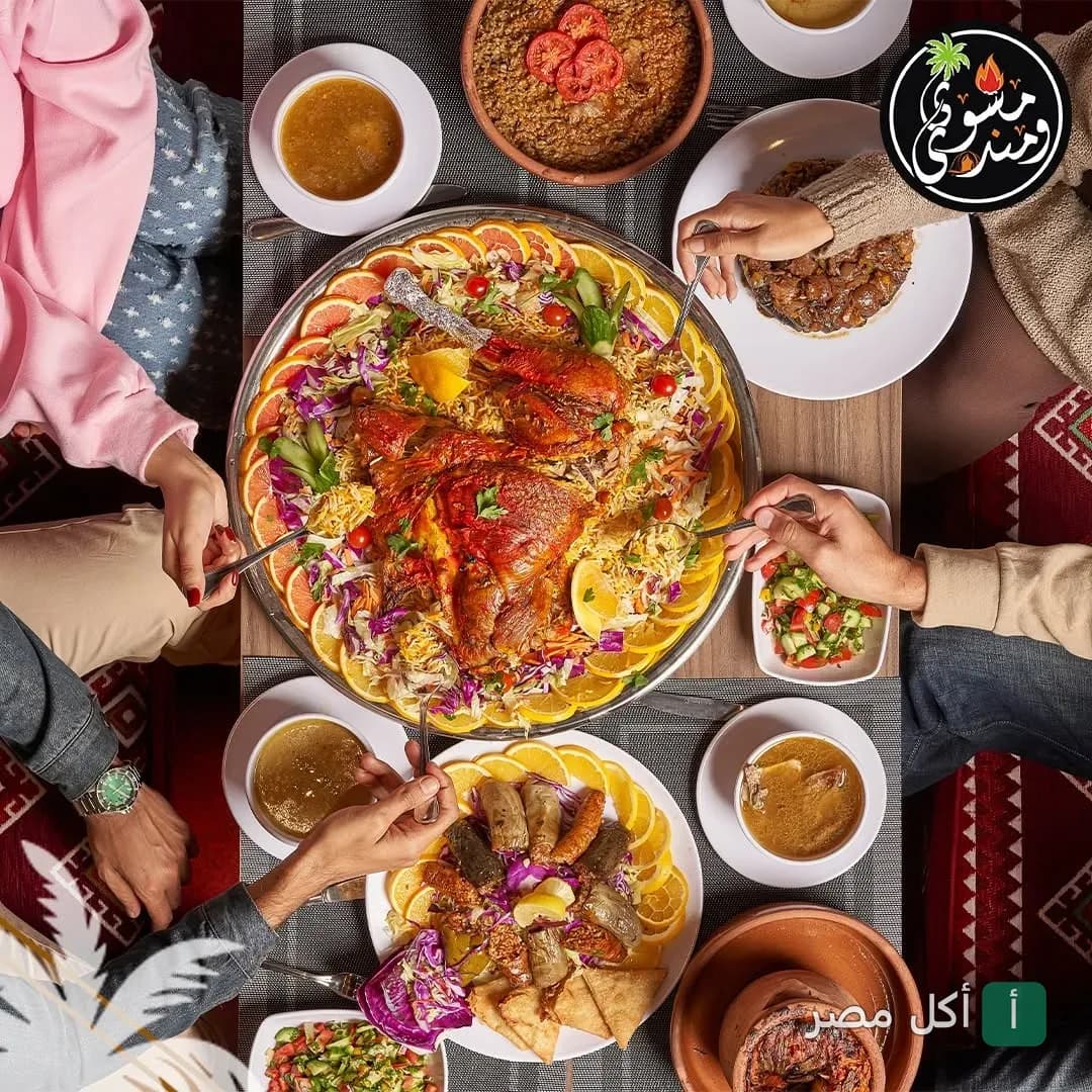 مجموعة من الأشخاص يتناولون وجبة مندي ومشاوي متنوعة في مطعم مشوي و مندي بجزيرة الدهب في الجيزة.