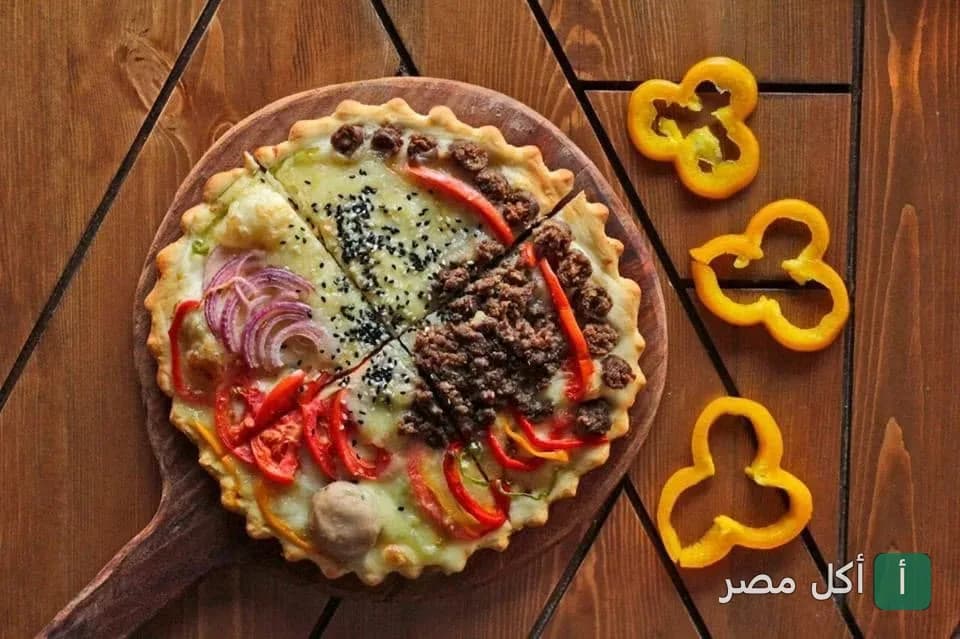 بيتزا متنوعة المكونات على لوح خشبي في مطعم هايدا اللبناني بالجيزة