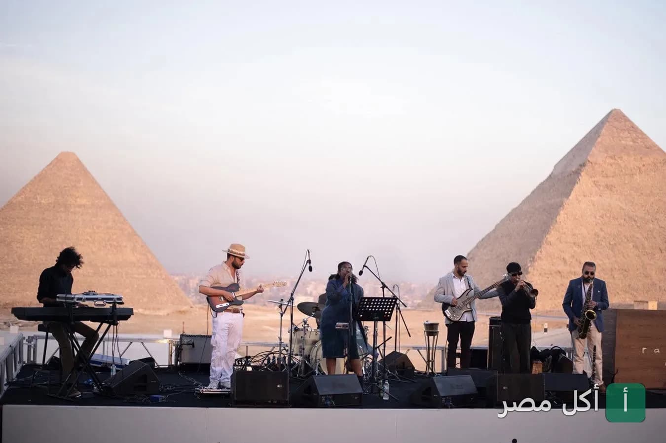 فرقة موسيقية تعزف على مسرح أمام أهرامات الجيزة في مطعم خوفو.