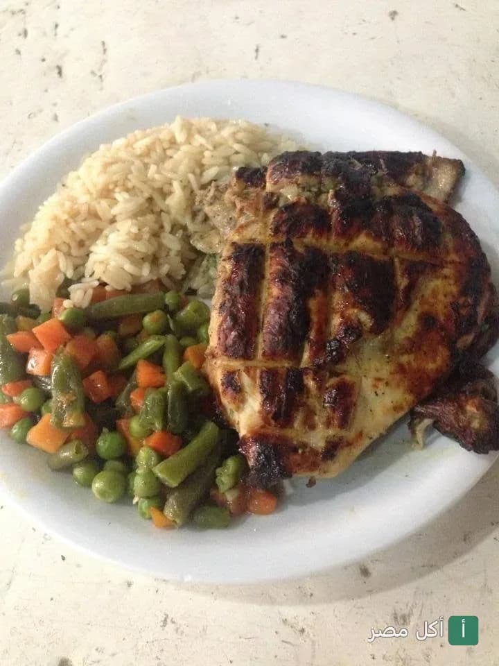 طبق دجاج مشوي مع أرز وخضار سوتيه في مطعم سمسمة بالدقي.