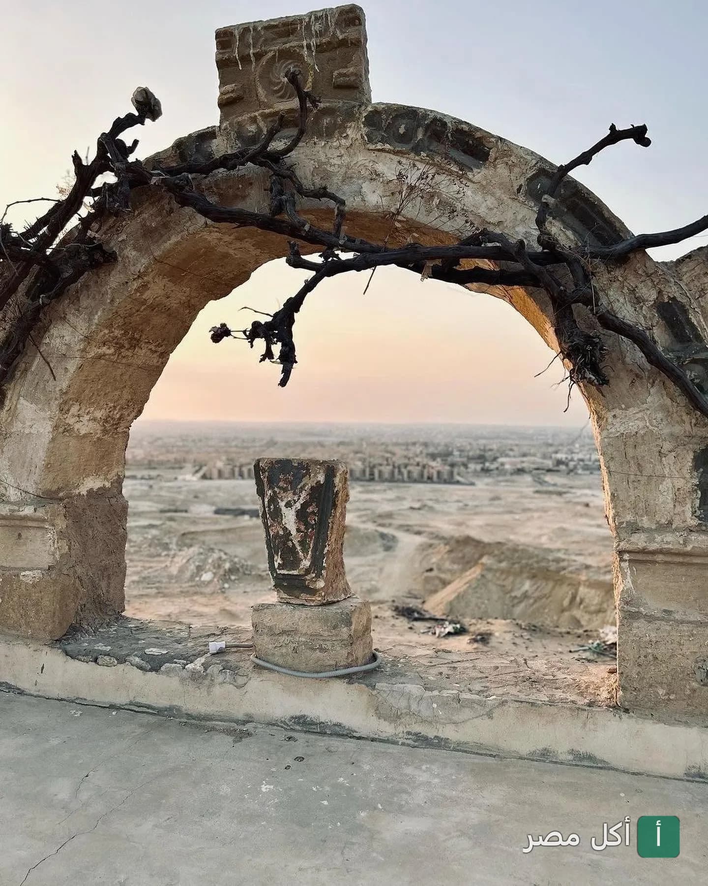 قوس حجري قديم يطل على منظر طبيعي صحراوي في مطعم أندريا المريوطية بالجيزة.