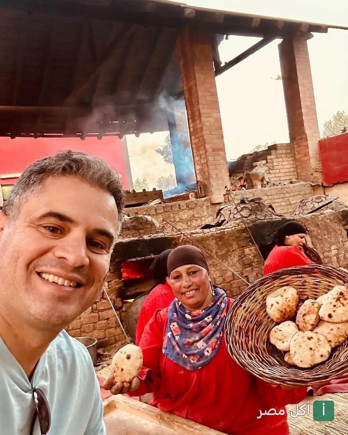 سيدة ريفية تحمل سلة خبز طازج خارج من فرن بلدي في مطعم أندريا المريوطية بالجيزة