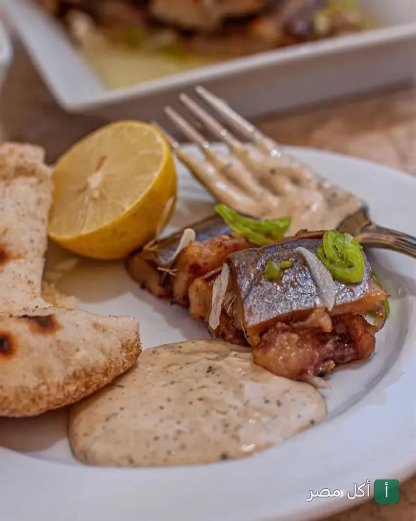 طبق سمك مشوي مع صوص الطحينة وليمون وخبز في مطعم أندريا المريوطية بالجيزة