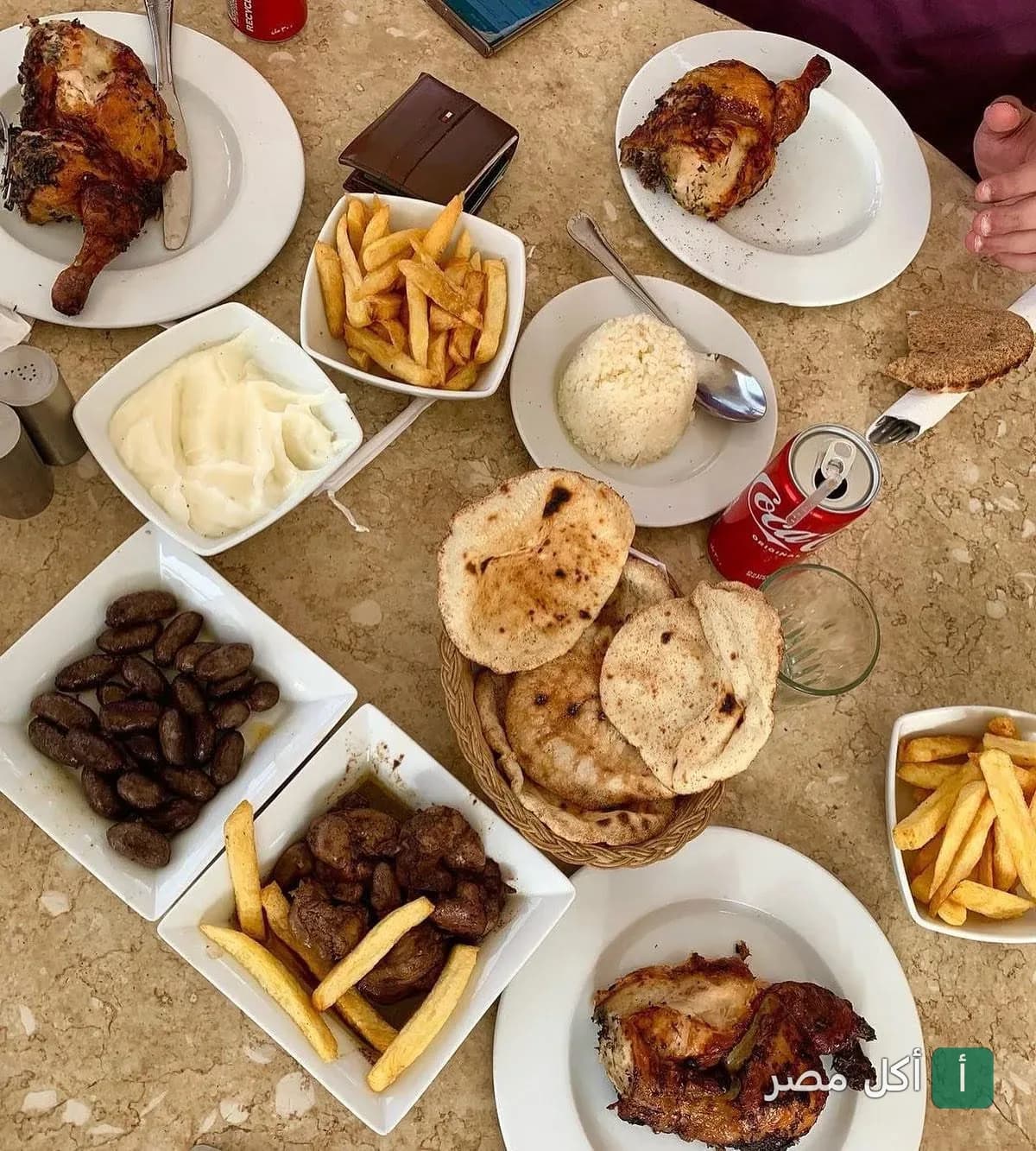 سفرة غداء متنوعة في مطعم أندريا المريوطية بالجيزة تضم دجاج مشوي، بطاطس مقلية، أرز، ومقبلات شرقية.