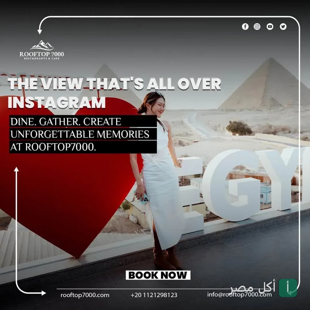 زائرة تلتقط صورة أمام مجسم قلب كبير وإطلالة مباشرة على أهرامات الجيزة في مطعم رووف توب 7000 بنزلة السمان.