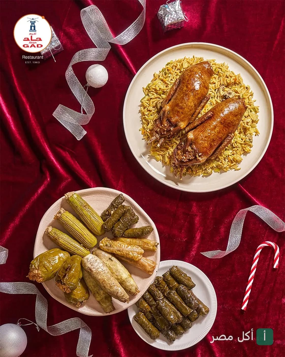 أطباق متنوعة من البط المحمر والمحاشي المصرية على مفرش أحمر في مطعم أكرم جاد بالجيزة.
