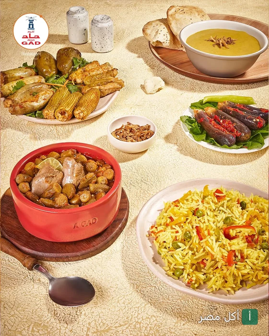 سفرة متنوعة من أطباق مطعم أكرم جاد في الجيزة، تشمل محاشي وطاجن بامية وأرز بالخضار.