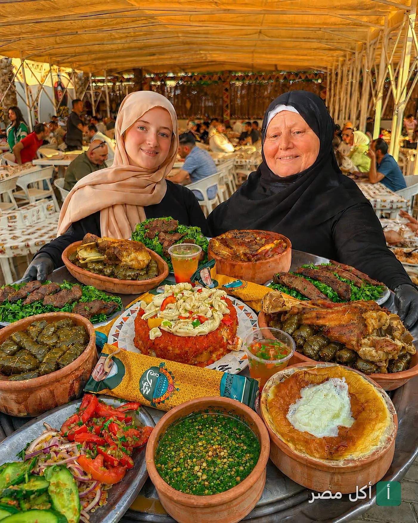 سيدتان تقدمان صينية كبيرة مليئة بأطباق المشاوي والأكلات الشرقية في مطعم حجوجة بالنزهة، الإسكندرية.