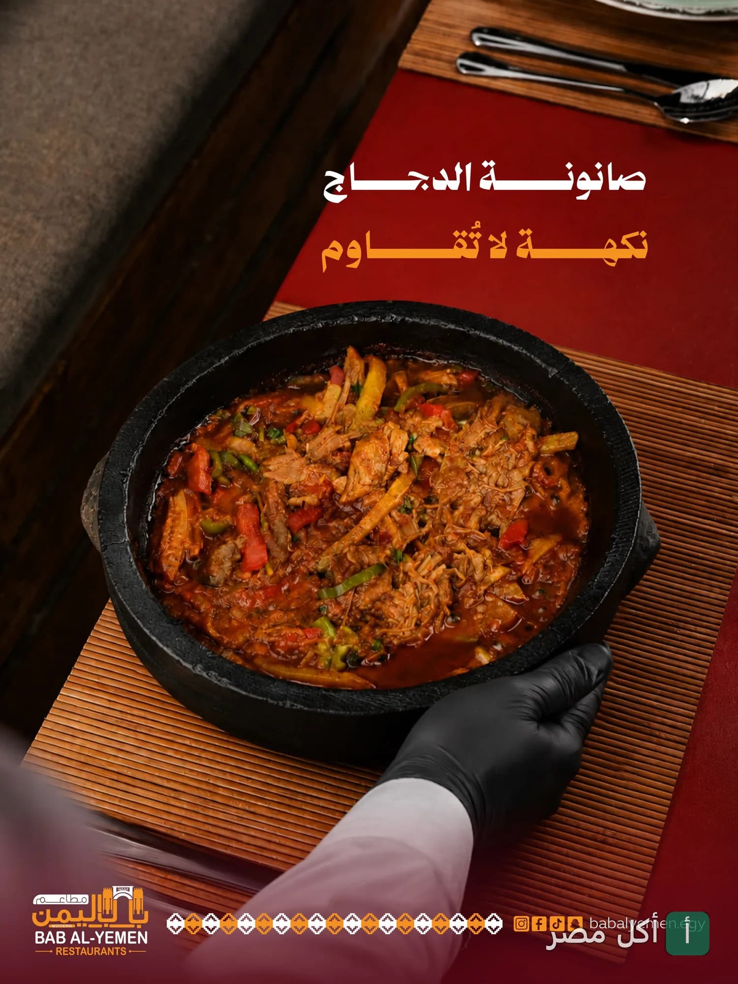 طبق صانونة دجاج يمني ساخن في وعاء حجري تقليدي من مطاعم باب اليمن الحديث.