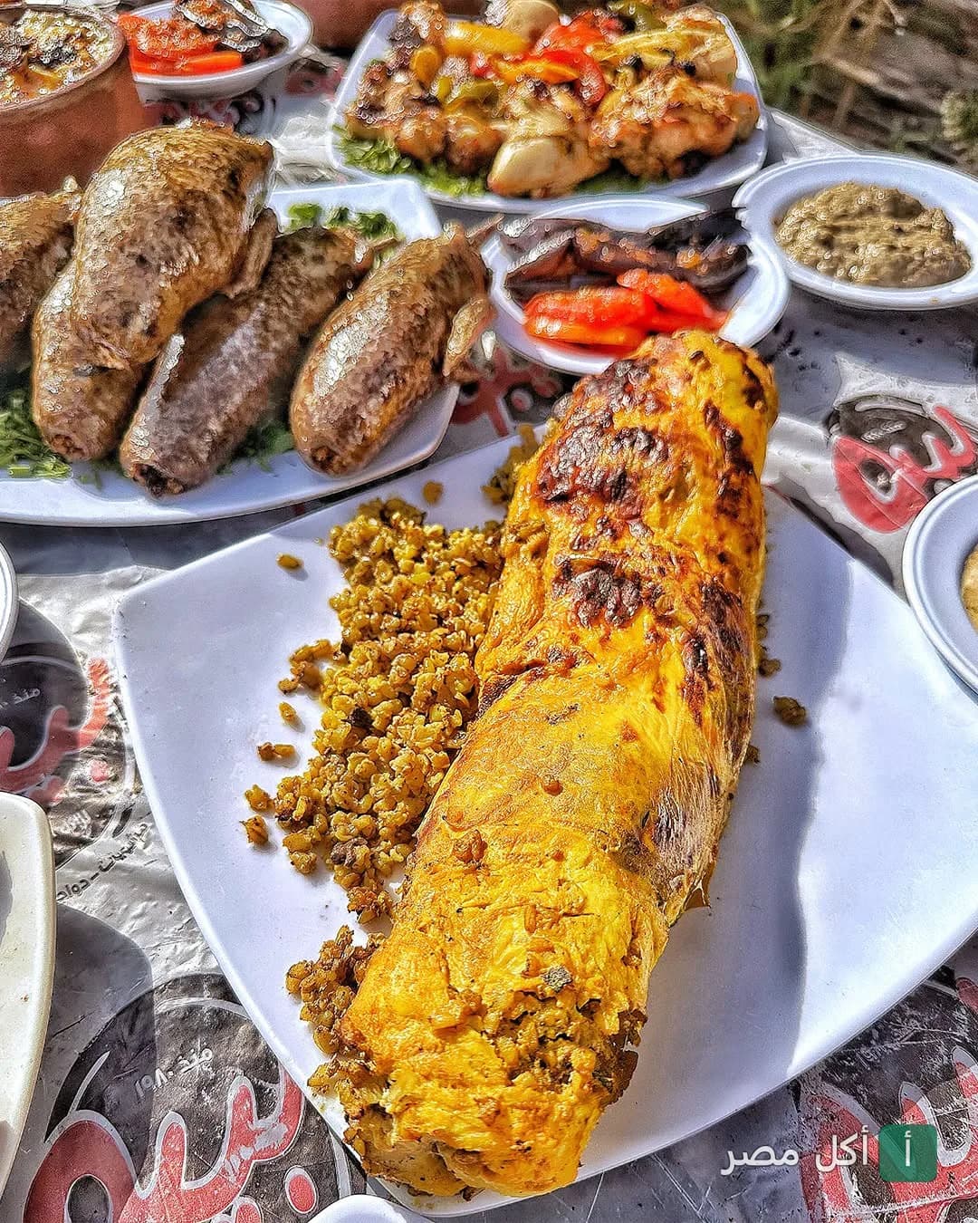 سفرة مشويات شرقية متنوعة تضم حمام محشي وأطباق أرز في مطعم بيبو.