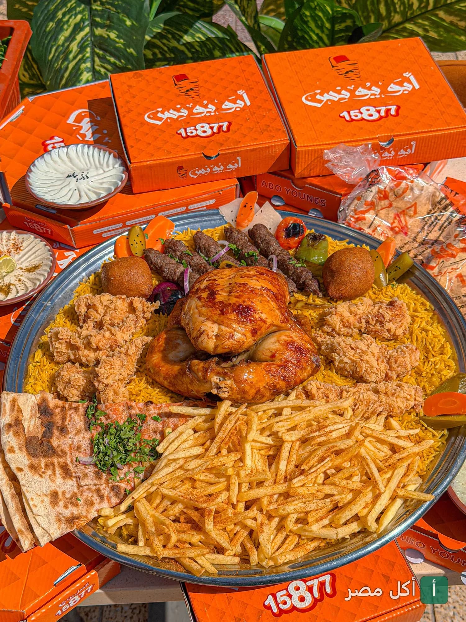 صينية مشويات سوري كبيرة من مطعم أبو يونس بالدخيلة، تضم دجاج مشوي، كفتة، بطاطس مقلية، وأرز.