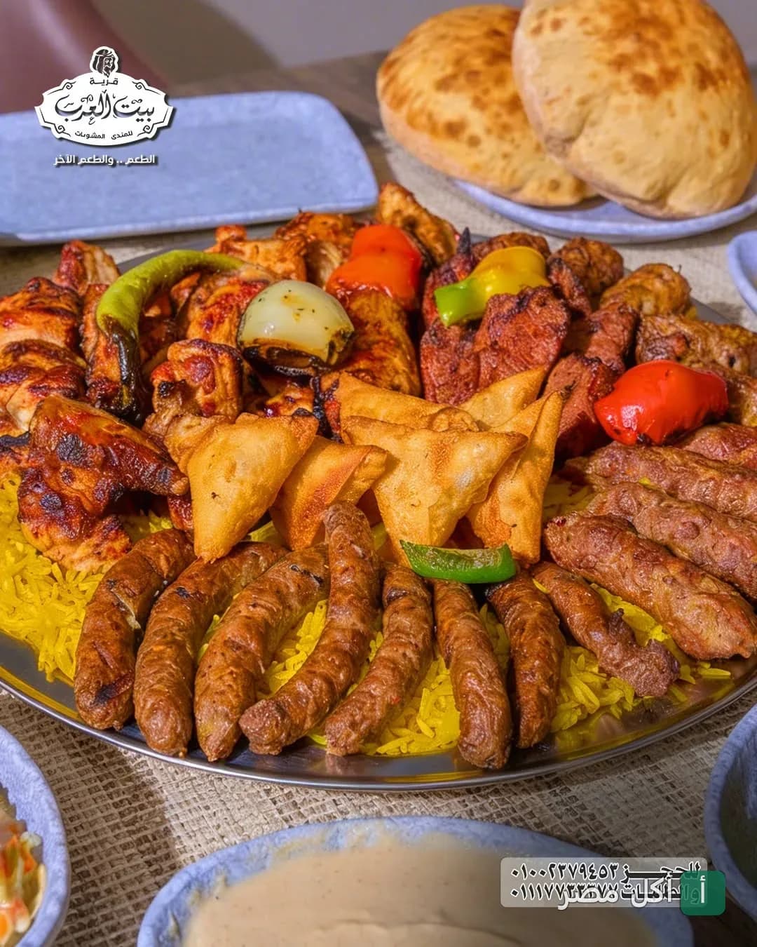 طبق مشويات مشكل من قرية شيخ العرب يضم كفتة، شيش طاووق، وسمبوسك على أرز أصفر