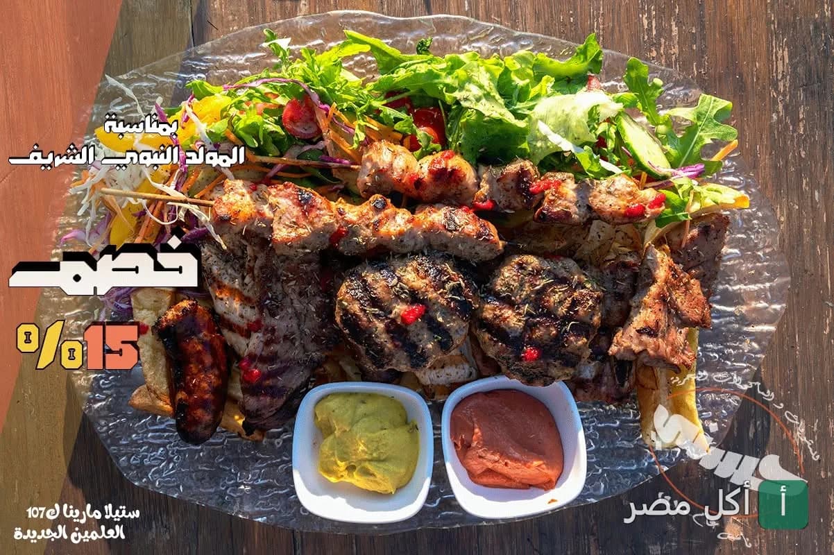طبق مشويات مشكل من مطعم مشويات حسني في الساحل الشمالي مع سلطة خضراء وصوصات.