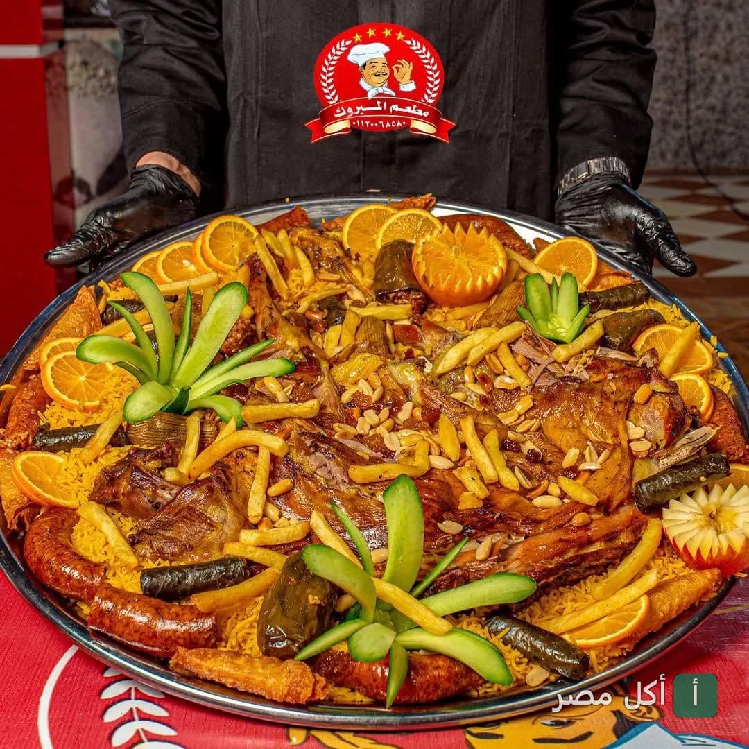 صينية مشاوي كبيرة من مطعم المبروك بسيدي عبدالرحمن، تحتوي على أرز ولحم ومحشي وبطاطس مقلية.