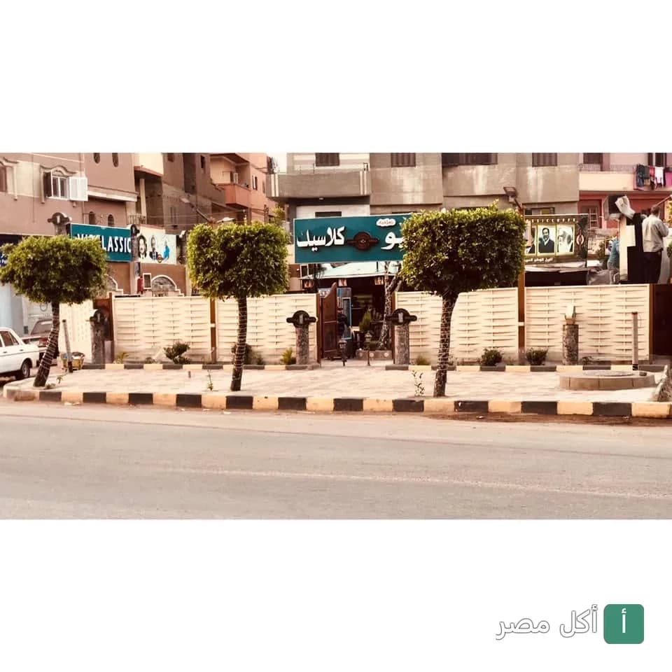 واجهة مطعم ومقهى نيو كلاسيك في السنطة، الغربية مع أشجار الزينة في المقدمة.