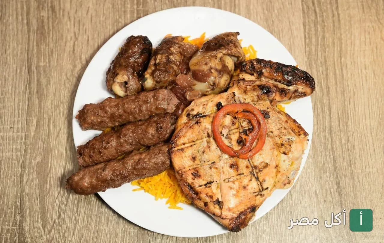 طبق مشويات مشكل من مطعم حضر موت السنطة يضم كفتة ودجاج مشوي على أرز أصفر.