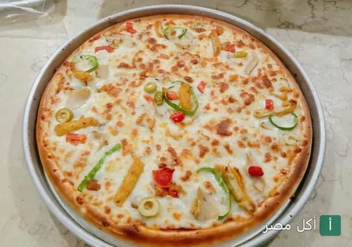 بيتزا بالجبنة والخضروات في صينية دائرية من مطعم زمزم في السنطة.