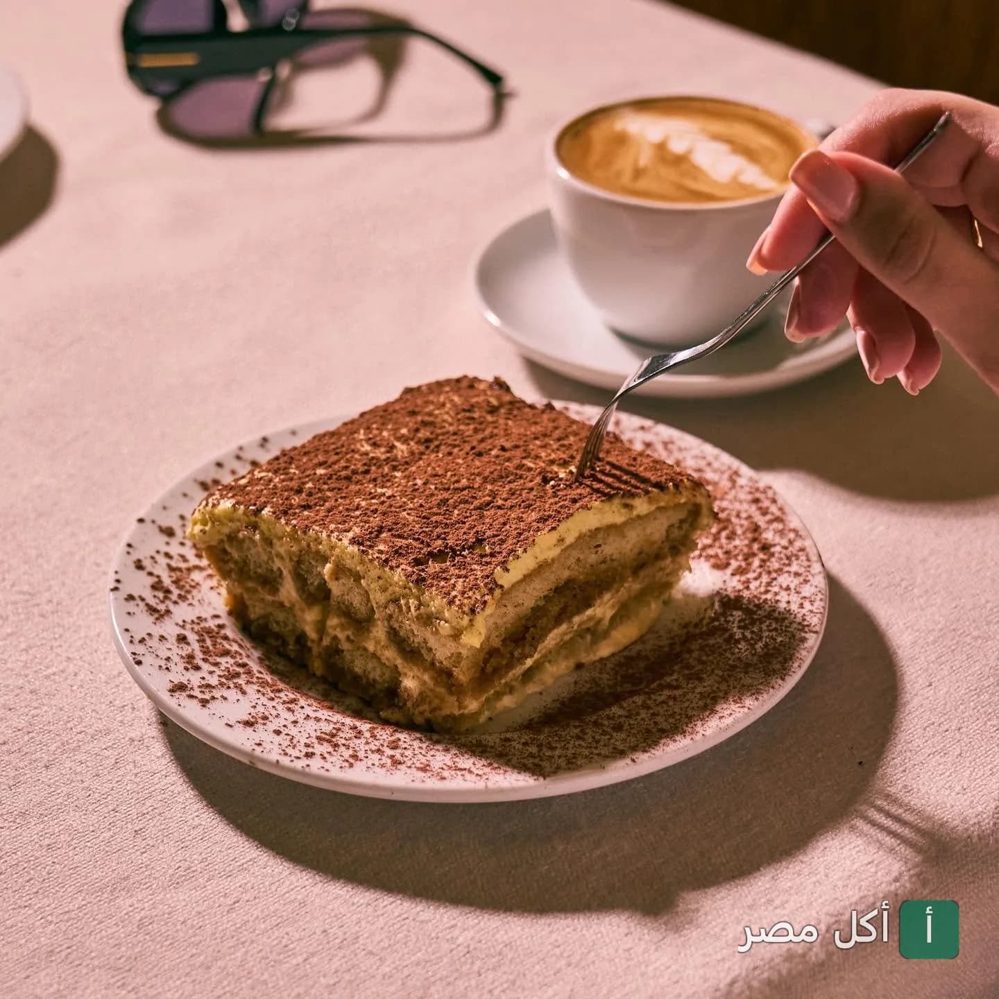 قطعة تيراميسو مع كوب قهوة في مطعم زيو ماركو بالزمالك