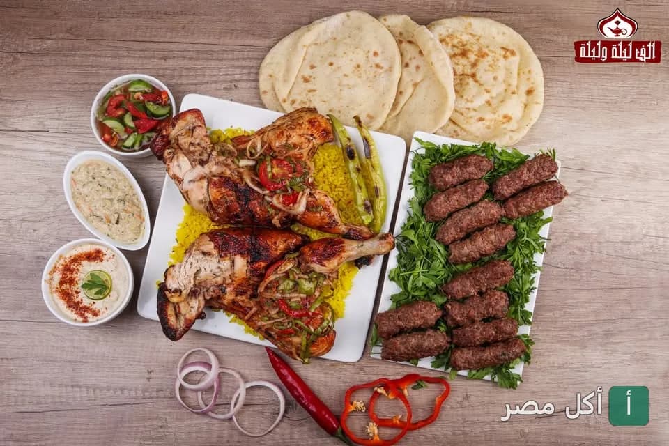 سفرة مشويات من مطعم ألف ليلة وليلة بالزمالك تضم دجاج مشوي وكفتة مع أرز ومقبلات وخبز.