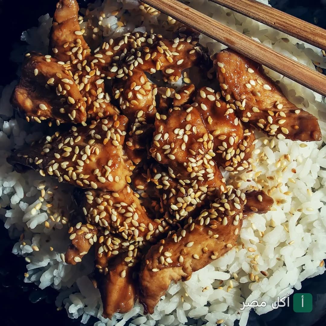 طبق أرز مع قطع دجاج بصوص الصويا والسمسم في مطعم أورانچيت بالزمالك