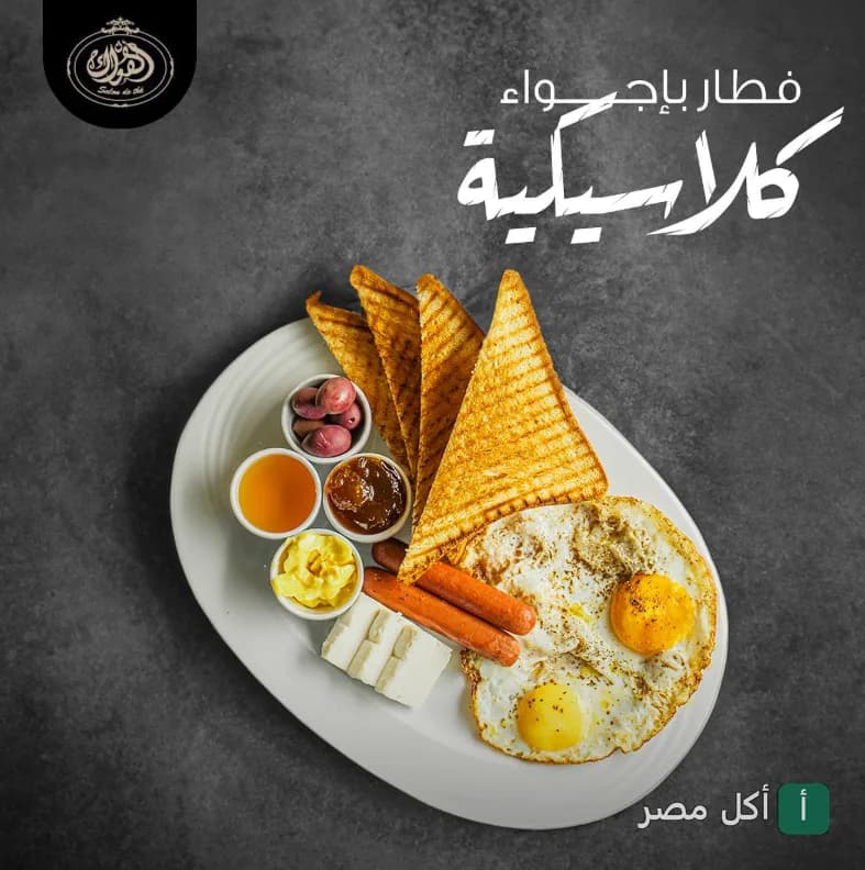طبق فطور كلاسيكي من اهواك - صالون دو تى بالزمالك، يضم بيض مقلي، توست محمص، نقانق، جبنة، ومربى.