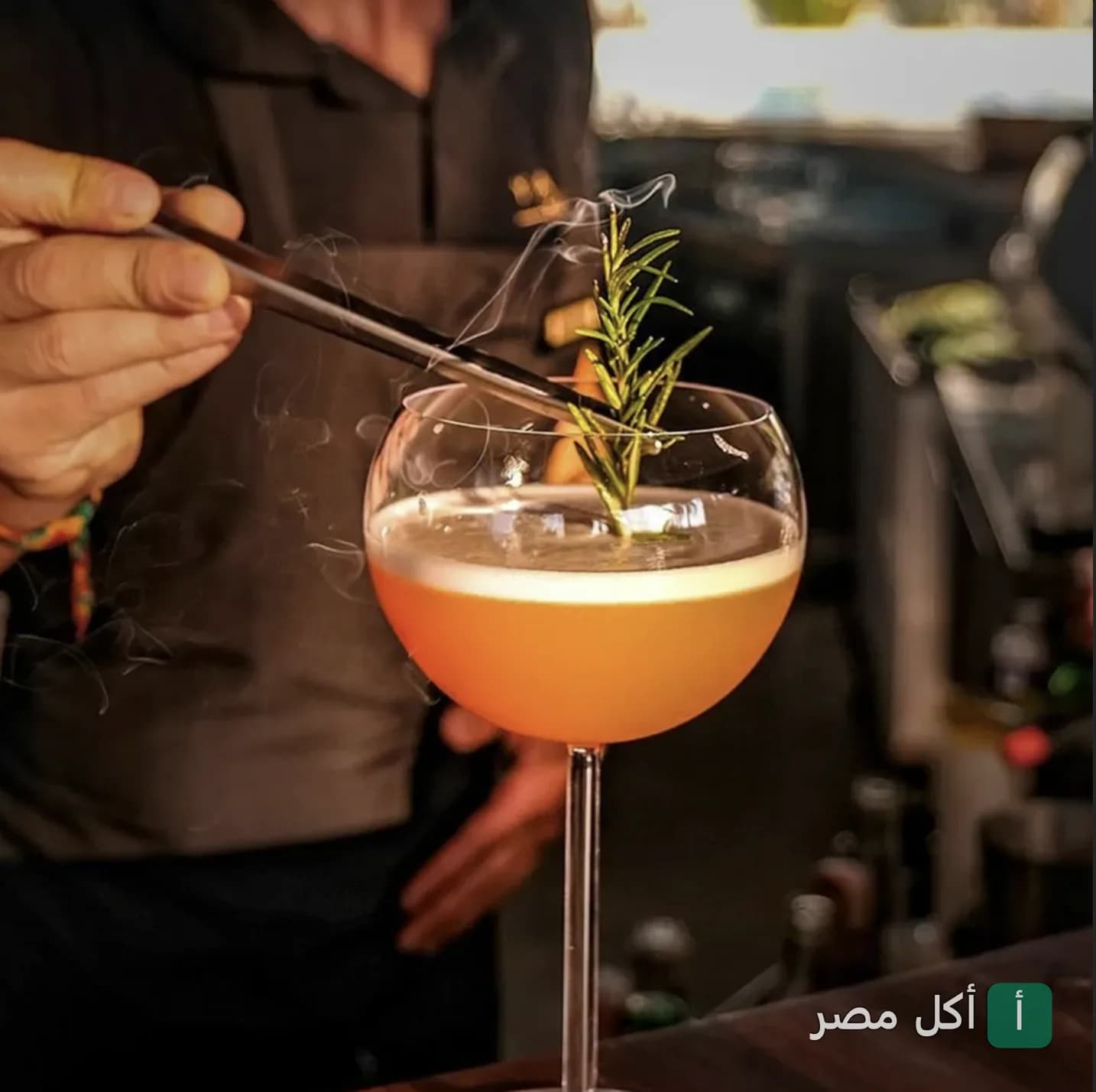 نادل يحضر كوكتيل مدخن ومزين بإكليل الجبل في مطعم آسيا بار بالزمالك.