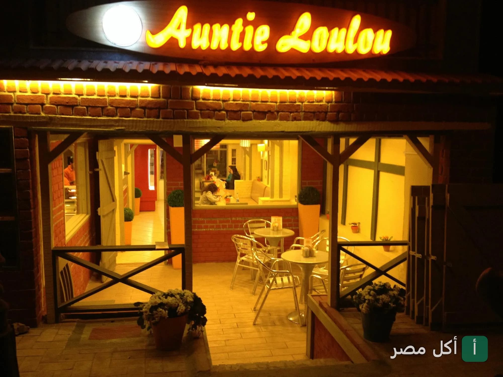 واجهة كافيه آنتي لولو في الزمالك، تظهر الجلسات الخارجية المريحة واللافتة المضيئة ليلاً.