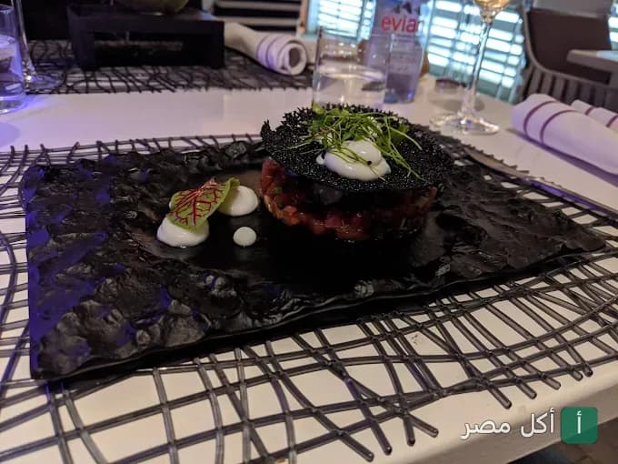 طبق تارتار مزين بلمسة فنية على طاولة مطعم لو ديك في الزمالك.