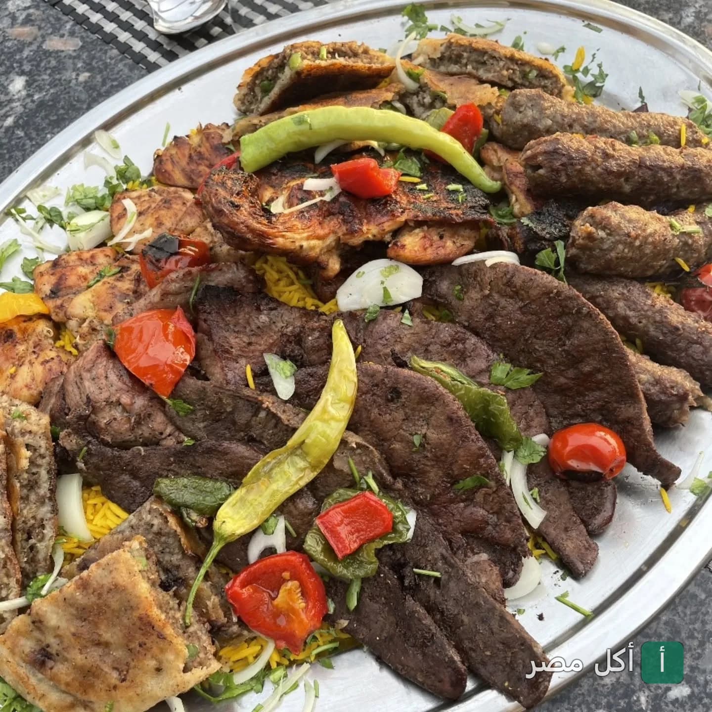 طبق مشويات مشكل يضم كفتة وكبدة ومشويات متنوعة على أرز في مطعم بنت السلطان بالقاهرة.