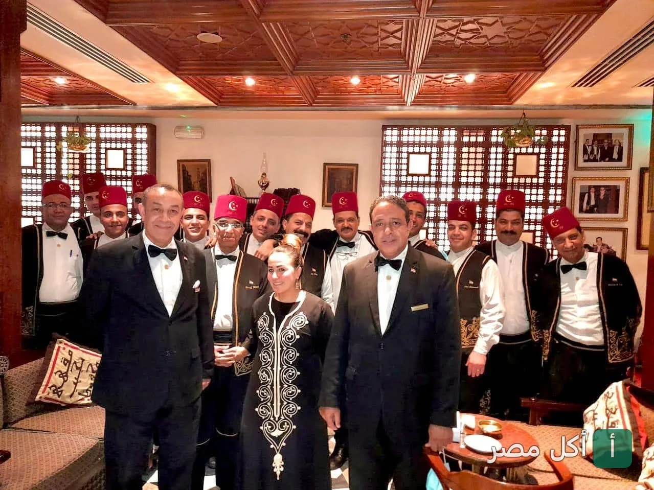 طاقم عمل مقهى نجيب محفوظ في خان الخليلي يرتدون الزي التقليدي والطربوش داخل المقهى ذو الطابع التراثي.