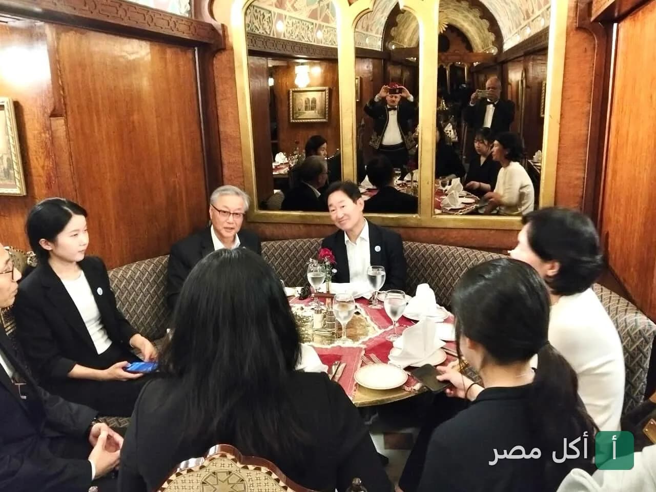 مجموعة من الأشخاص يجلسون حول مائدة مستديرة في مقهى نجيب محفوظ التاريخي بخان الخليلي.