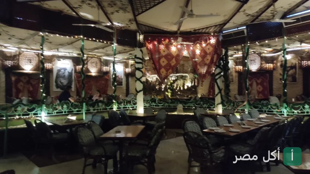 ديكور داخلي وجلسات مطعم وحديقة الجريون في القاهرة مع إضاءة دافئة وزينة شرقية.