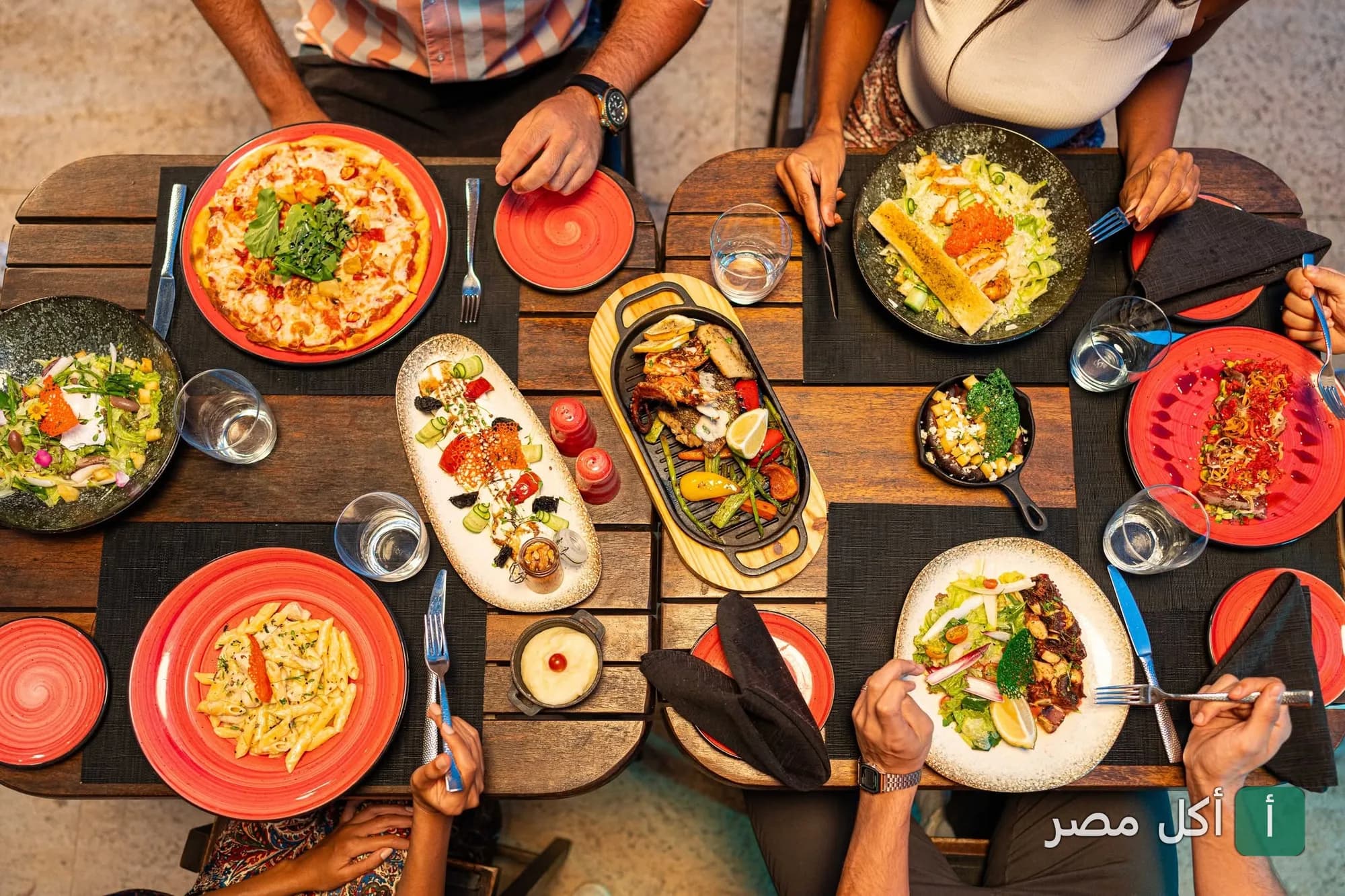 مائدة طعام متنوعة تضم أطباق البيتزا والمشاوي والسلطات في مطعم سوليس بالمعادي.