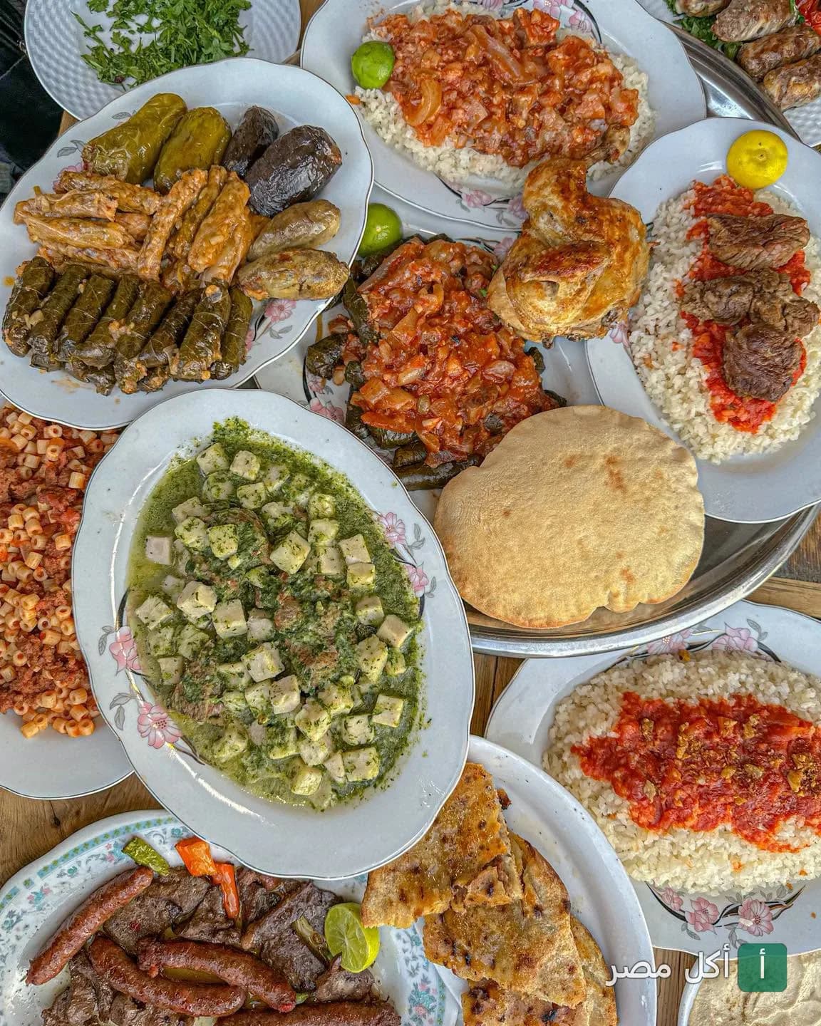 سفرة عامرة بأطباق مصرية متنوعة مثل المحاشي، الملوخية، الفتة، والمشاوي في مطعم القاهرة ٣٠ بالخليفة.