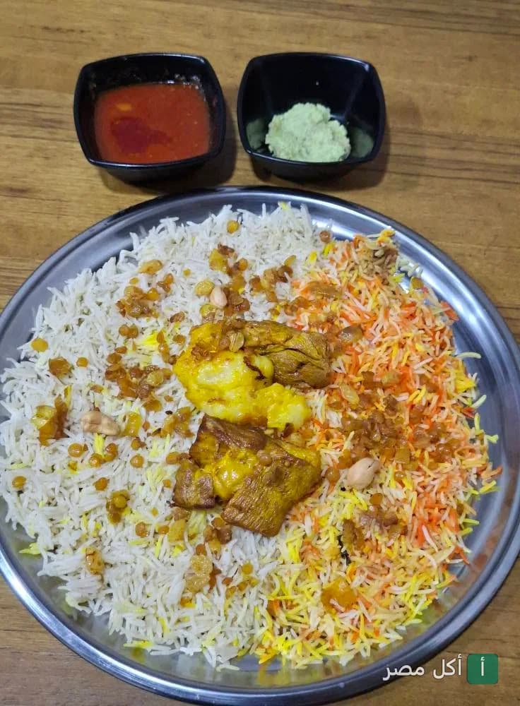 طبق أرز هندي ملون مع قطع دجاج في مطعم إندو-بانجلا بالمنيل، القاهرة.