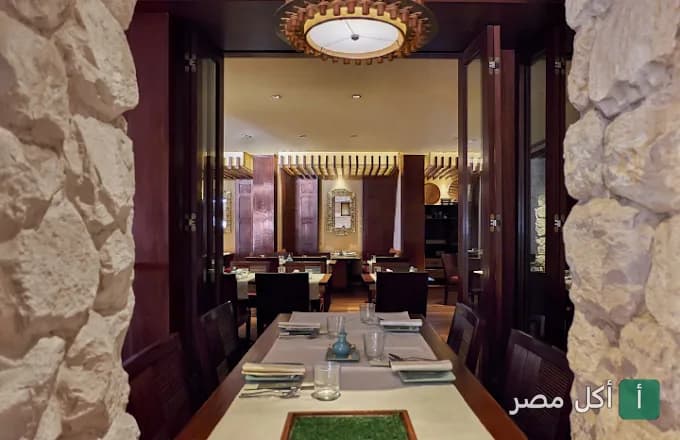 طاولات طعام مرتبة داخل مطعم البيرد كيج في قصر الدوبارة بالقاهرة.